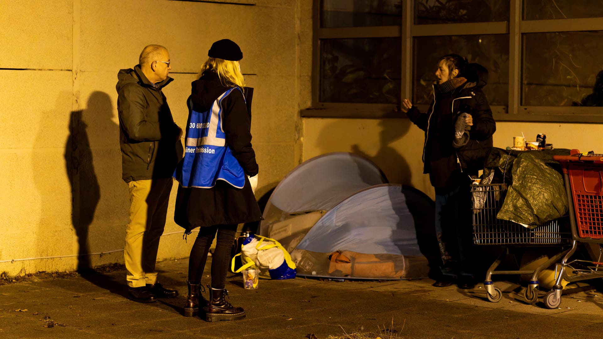 Olli und Karla unterhalten sich mit Tanja vor ihrem Lager an der Schwimmhalle: Seit drei Wintern besuchen sie die Obdachlose regelmäßig.