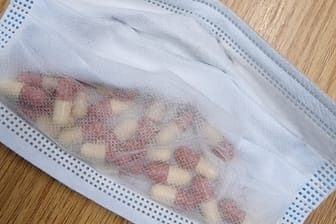Zwei mutmaßliche Drogendealer haben Pillen in einem Mund-Nasen-Schutz versteckt.