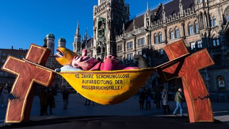 Die Plastik „Der Hängemattenbischof“ steht auf dem Marienplatz in München.