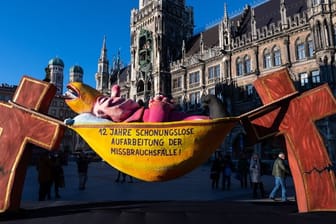 Die Plastik „Der Hängemattenbischof“ steht auf dem Marienplatz in München.