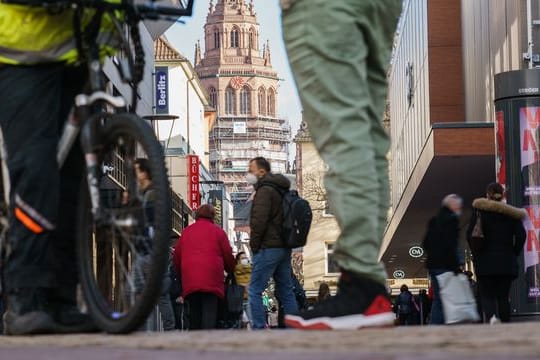 Menschen gehen durch eine Einkaufspassage in der Mainzer Innenstadt.