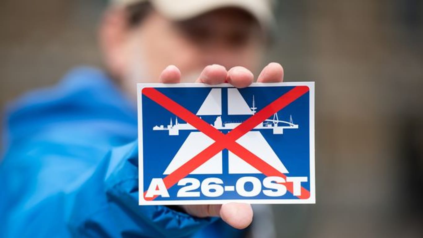 Ein Aufkleber mit dem durchgestrichenen Schriftzug "A26-OST": Wird das Projekt doch noch gestoppt?
