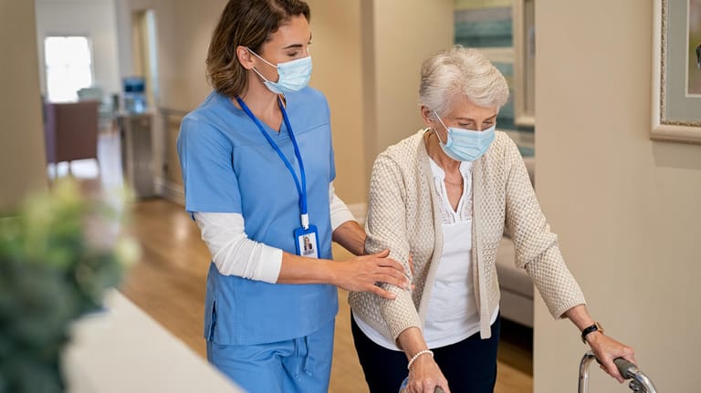 Pflegerin hilft älterer Dame beim Gehen: Bei der Wahl einer Pflegeeinrichtung gibt es viele Kriterien, die zu beachten sind. Eine gute Vorbereitung ist dabei die Voraussetzung.