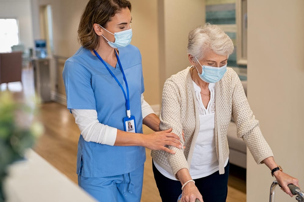 Pflegerin hilft älterer Dame beim Gehen: Bei der Wahl einer Pflegeeinrichtung gibt es viele Kriterien, die zu beachten sind. Eine gute Vorbereitung ist dabei die Voraussetzung.