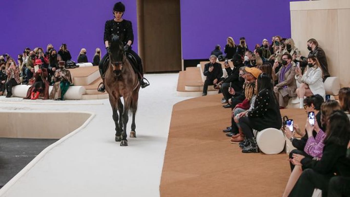 Ein Model reitet auf einem Pferd während der Präsentation der Modekollektion von Chanel für Frühjahr-Sommer 2022.
