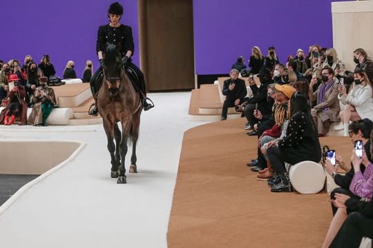 Ein Model reitet auf einem Pferd während der Präsentation der Modekollektion von Chanel für Frühjahr-Sommer 2022.