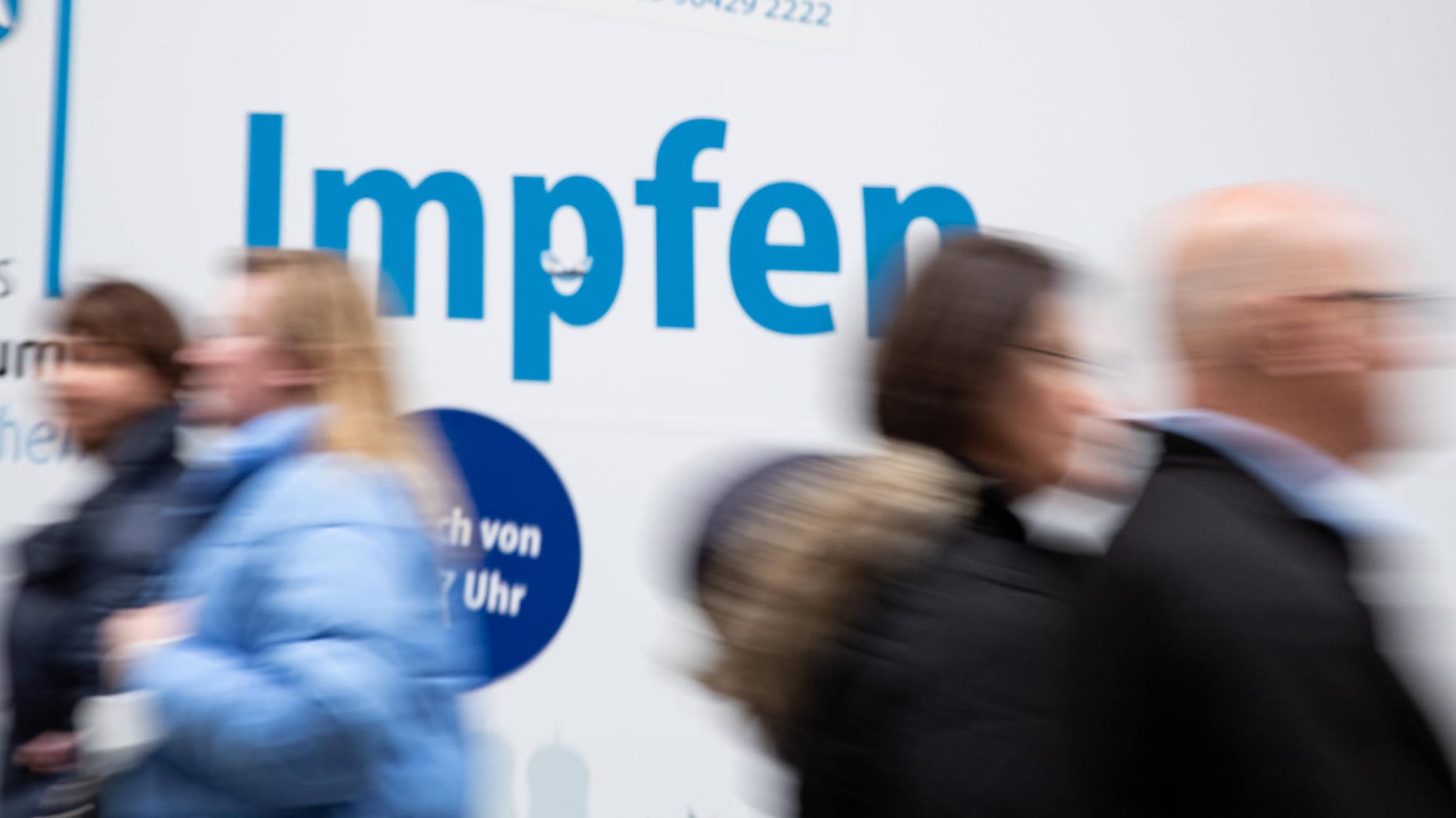 Menschen gehen an einem Impfzentrum in München vorbei: "Wir möchten bei der Impfpflichtdebatte für den Mittelweg werben". Menschen gehen an einem Impfzentrum in München vorbei: "Wir möchten bei der Impfpflichtdebatte für den Mittelweg werben".