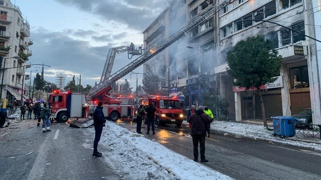 Feuerwehrleute suchen mit Hilfe von Drehleitern nach Personen, die nach einer Explosion in den beschädigten Gebäuden eingeschlossen sind. Feuerwehrleute suchen mit Hilfe von Drehleitern nach Personen, die nach einer Explosion in den beschädigten Gebäuden eingeschlossen sind.