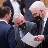 Ministerpräsident Kretschmann (r) spricht im Plenarsaal mit Innenminister Strobl (m) und CDU-Fraktionsvorsitzendem Hagel (l): Der Beschluss lässt keine Fastnachtsumzüge zu.
