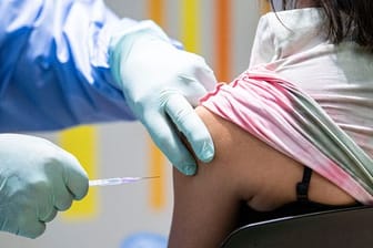 Eine Person wird im Impfzentrum Tegel von einem Impfarzt gegen das Coronavirus geimpft.