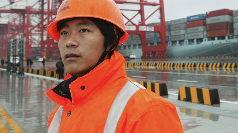 Mitarbeiter vor dem Yangshan-Tiefseehafen in Shanghai: Es ist der größte Hafen der Welt – und in der Stadt sind bereits erste Omikron-Fälle aufgetreten.