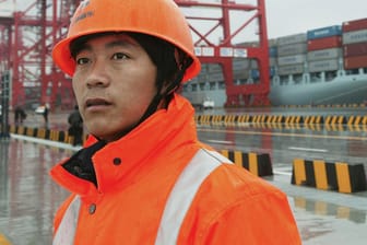 Mitarbeiter vor dem Yangshan-Tiefseehafen in Shanghai: Es ist der größte Hafen der Welt – und in der Stadt sind bereits erste Omikron-Fälle aufgetreten.