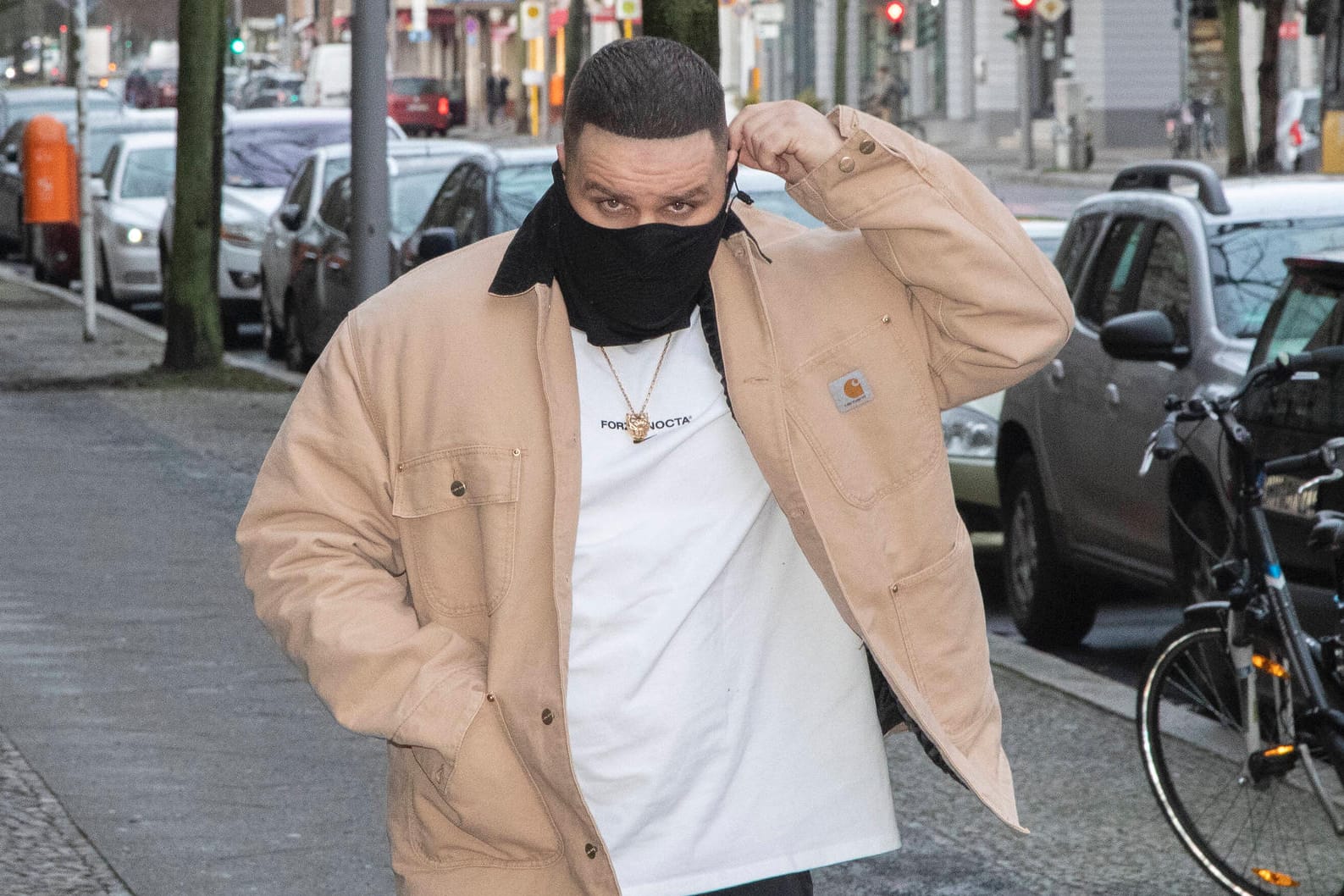 Der Rapper Fler trägt ein Tuch als Mundschutz (Archivbild): Er konnte am Mittwoch nicht vernommen werden.