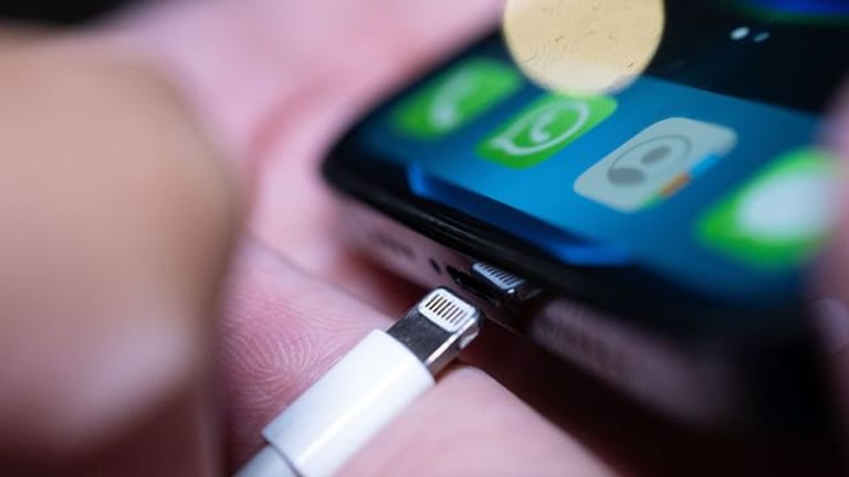 Ein Lightning-Ladestecker wird in ein Apple iPhone gesteckt.