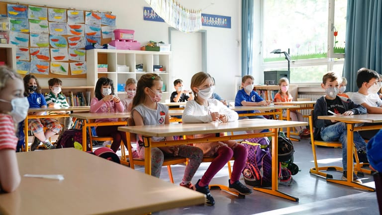 Schulklasse sitzt mit Maske im Unterricht (Symbolbild): In Hamburg werden an allen Schulen nun wieder Schnelltests verwendet.