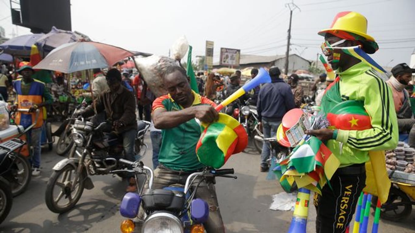 Ein Mann verkauft in Kameruns Hauptstadt Jaunde Flaggen und Hüte des WM-Gastgebers auf der Straße.