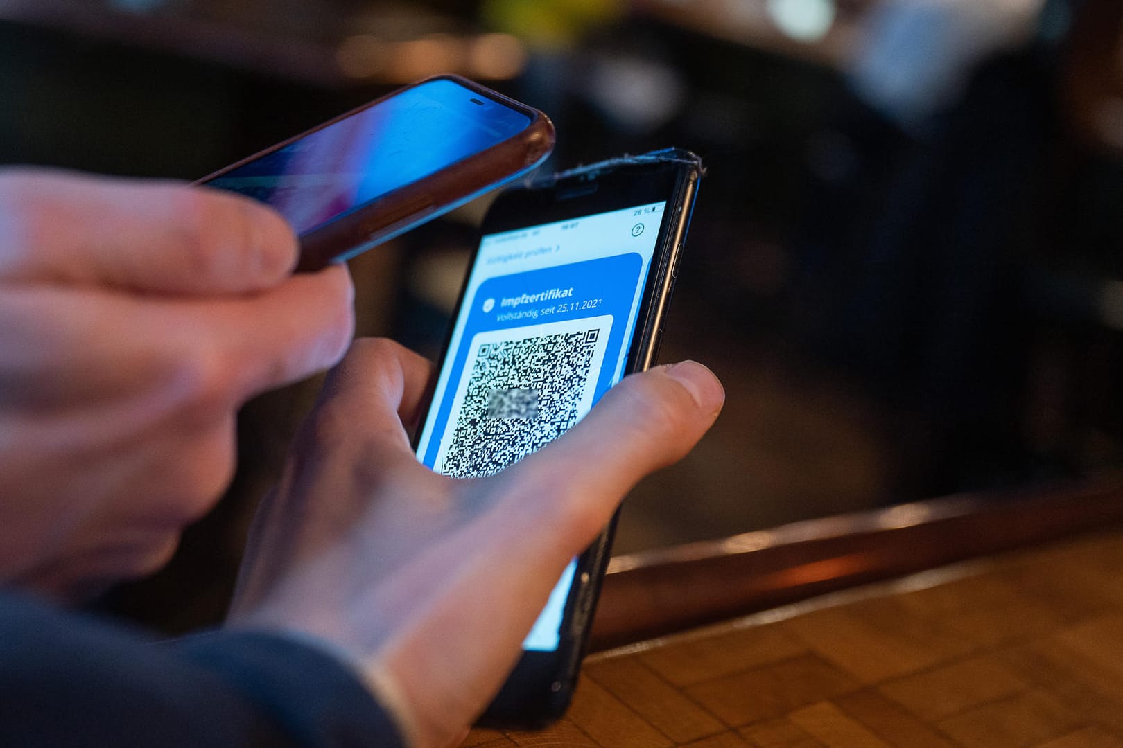 Mitarbeiter prüft ein Impfzertifikat (Symbolbild): Laut einem Bericht wurden Millionen mehr digitale Zertifikate ausgestellt als Impfdosen verabreicht.