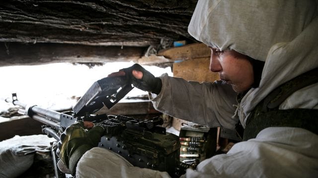 Ein ukrainischer Soldat in den umkämpften Gebieten im Osten des Landes überprüft ein Maschinengewehr.