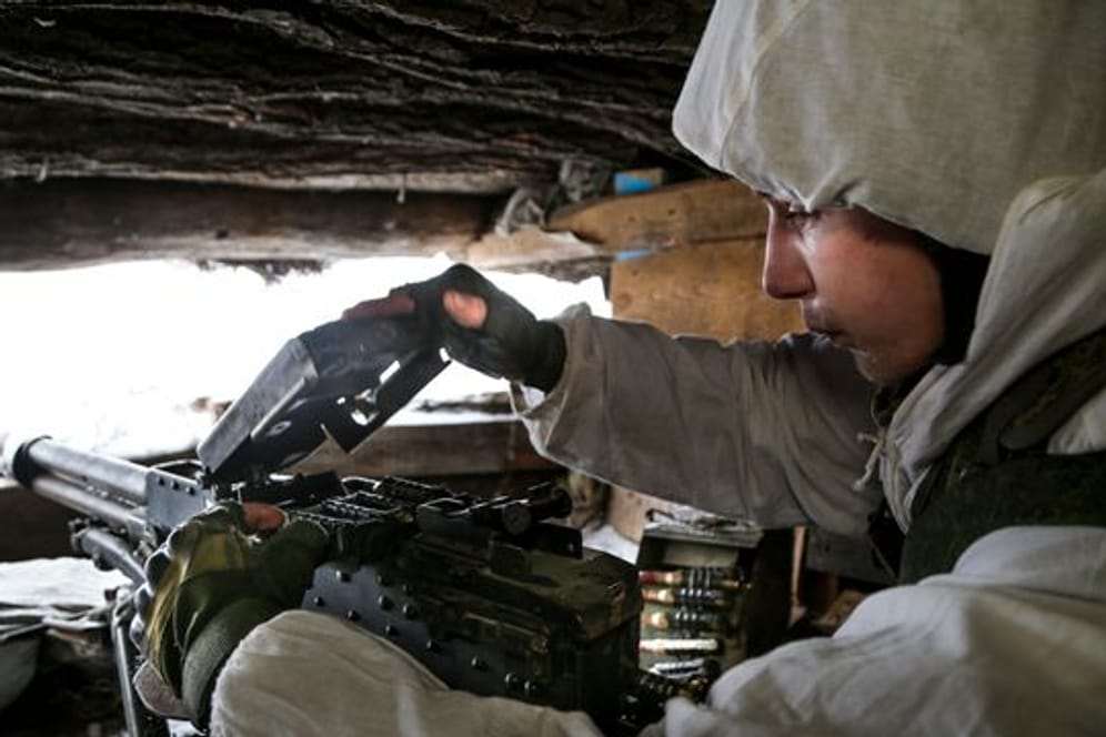 Ein ukrainischer Soldat in den umkämpften Gebieten im Osten des Landes überprüft ein Maschinengewehr.