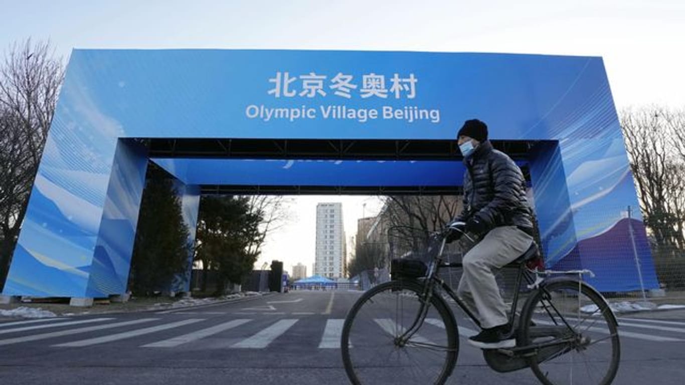 Ein Mann fährt in der Nähe des Athletendorfs in der chinesischen Hauptstadt Peking Fahrrad.