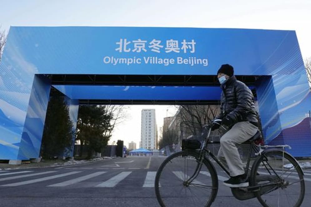 Ein Mann fährt in der Nähe des Athletendorfs in der chinesischen Hauptstadt Peking Fahrrad.