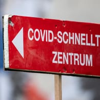 Ein Schild weist den Weg zu einem Corona-Schnelltestzentrum (Symbolbild): Aufgrund von Überlastung durch Meldeverzögerungen werden Infizierte vorerst nicht mehr kontaktiert.