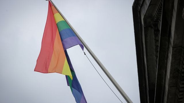 Eine Regenbogenflagge hängt an einem Masten