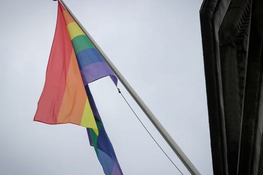 Eine Regenbogenflagge hängt an einem Masten