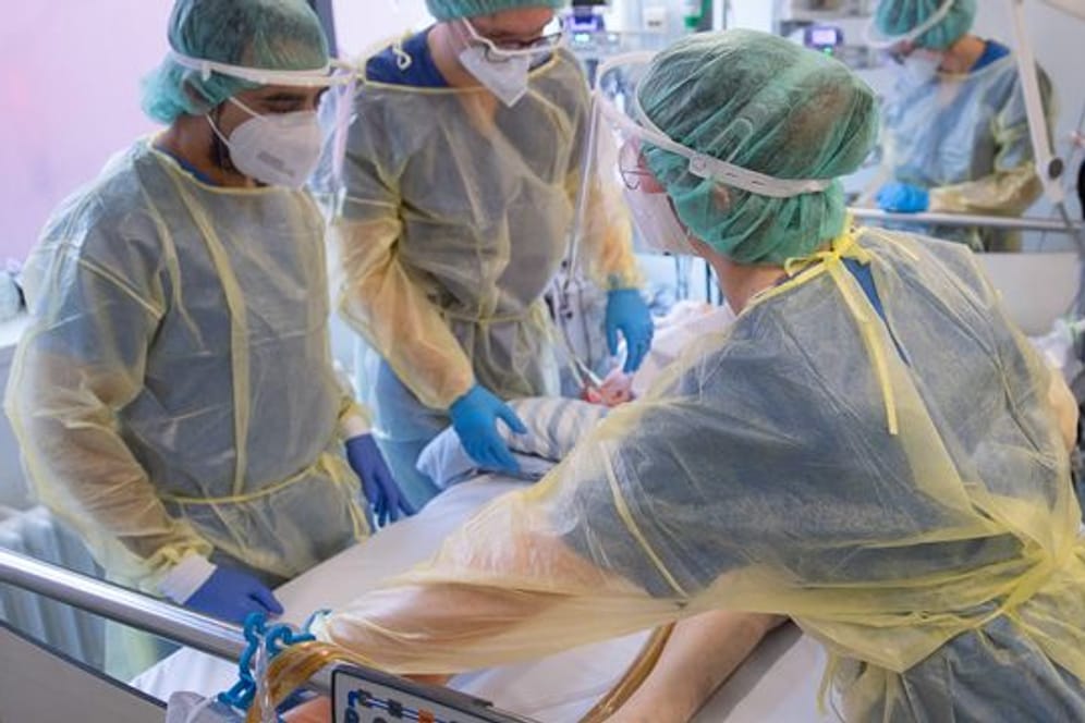 Pflegende und eine Ärztin kümmern sich auf einer Corona-Intensivstation in Offenbach um einen Patienten.
