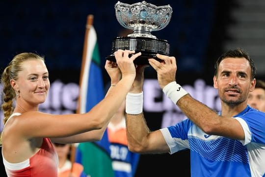 Kristina Mladenovic und Ivan Dodig halten ihre Trophäe nach ihrem Sieg in die Höhe.