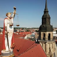 Justitia auf dem Dach des Landgerichts Halle an der Saale (Symbolbild): Ein Tatverdächtiger schweigt bislang zu einer gewalttätigen Attacke mit einer Axt.