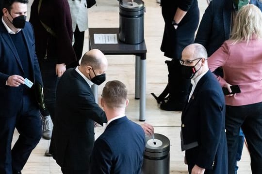 Bundeskanzler Olaf Scholz gibt bei der namentlichen Abstimmung über die Verlängerung des Bundeswehreinsatzes im Irak seine Stimmkarte ab.