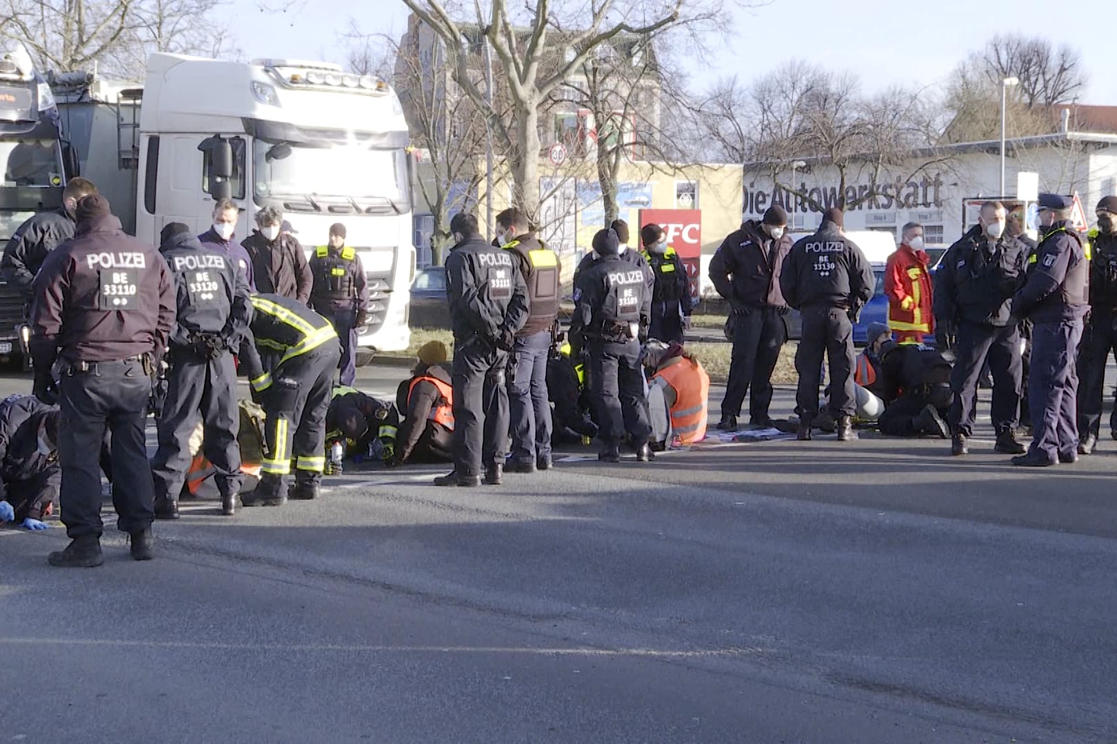 Polizisten, Sanitäter und Klimaaktivisten auf einer Straße in Berlin: Einige Protestierende hatten ihre Hände auf der Straße angeklebt.