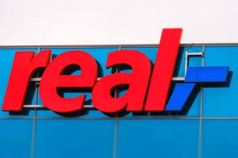 Das Logo von Real an einer Filiale der Kette: An einer Reihe von Geschäften bleiben sie hängen.