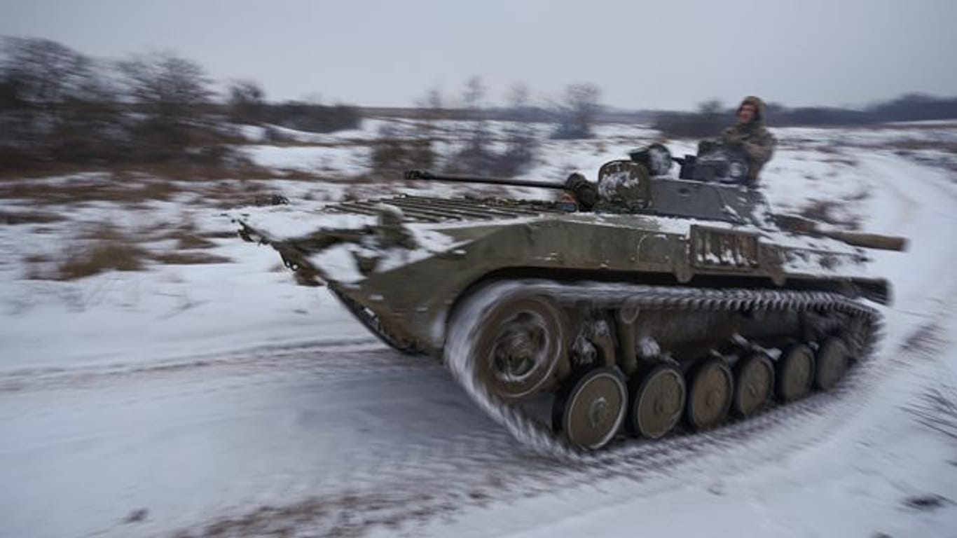 Ukrainische Soldaten fahren mit einem gepanzerten Mannschaftstransportwagen durch den Schnee. Ukrainische Soldaten fahren mit einem gepanzerten Mannschaftstransportwagen durch den Schnee.