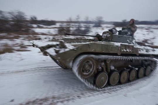 Ukrainische Soldaten fahren mit einem gepanzerten Mannschaftstransportwagen durch den Schnee.