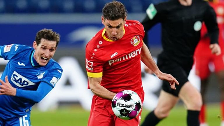 Leverkusens Lucas Alario (M) versucht den Ball gegen Hoffenheims Sebastian Rudy (l) zu behaupten.