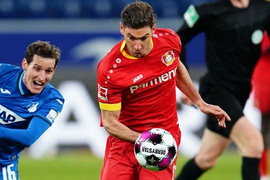 Leverkusens Lucas Alario (M) versucht den Ball gegen Hoffenheims Sebastian Rudy (l) zu behaupten.