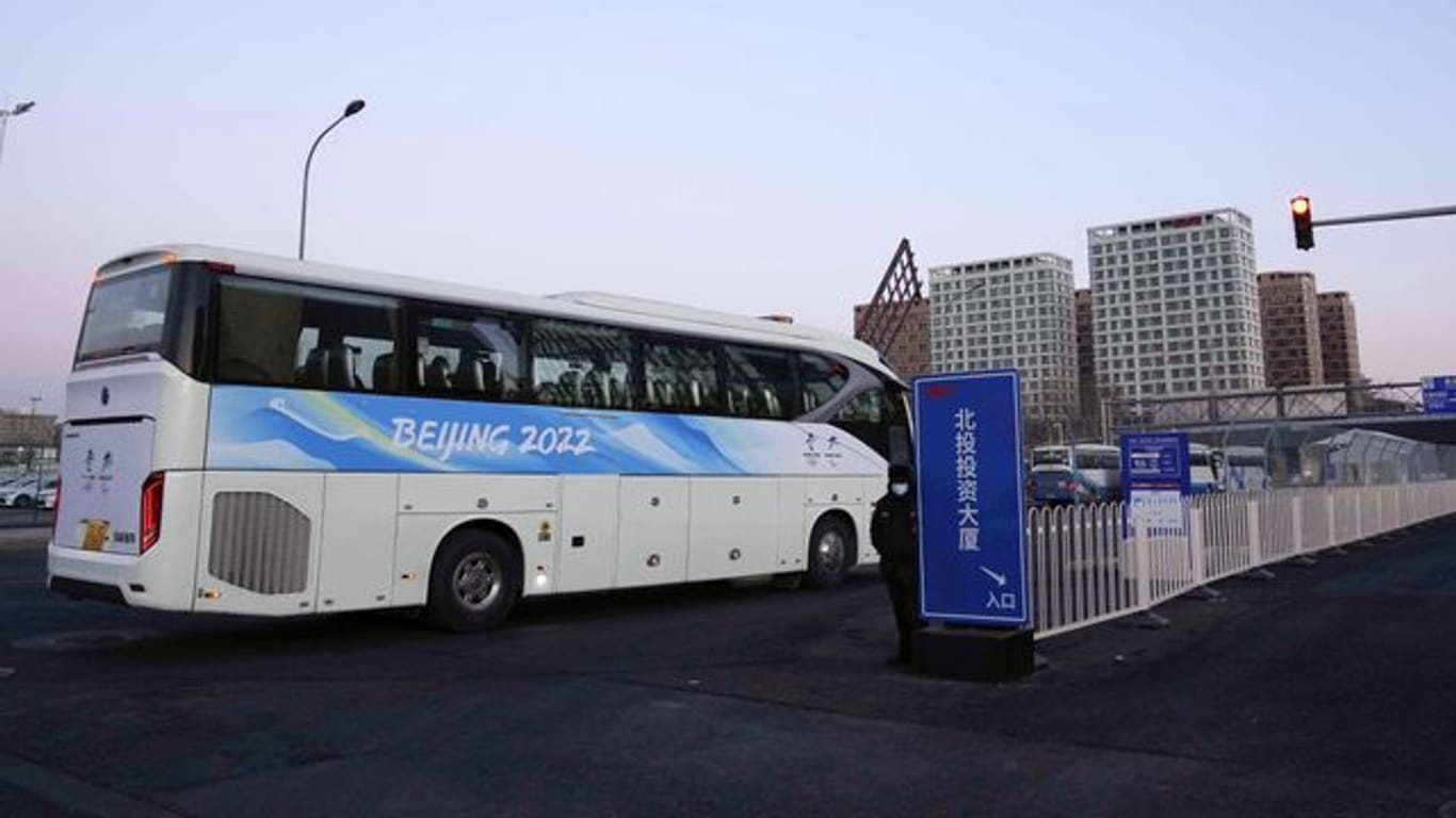 Ein Bus für Menschen, die mit den Olympischen Winterspielen in Peking zu tun haben, fährt in das Athletendorf ein.