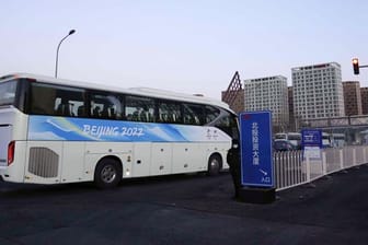 Ein Bus für Menschen, die mit den Olympischen Winterspielen in Peking zu tun haben, fährt in das Athletendorf ein.