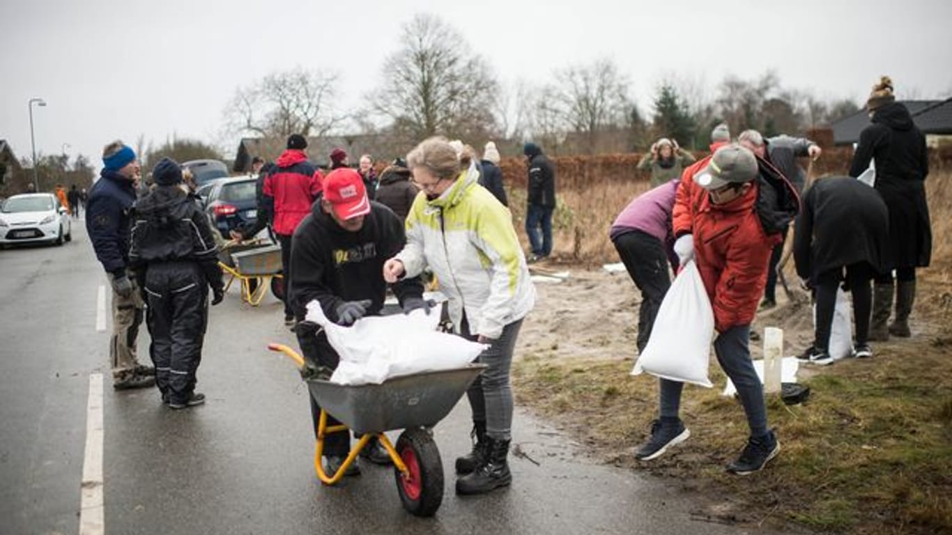 Im dänischen Odense füllen Bewohner Sandsäcke auf, um sich vor Sturm "Malik" zu schützen.