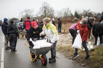 Im dänischen Odense füllen Bewohner Sandsäcke auf, um sich vor Sturm "Malik" zu schützen.
