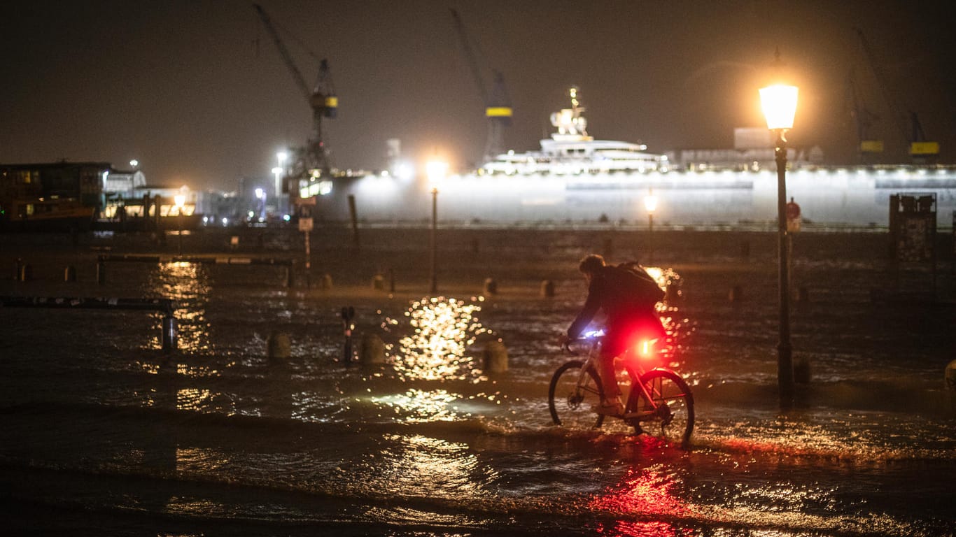 Radfahrer am überfluteten Fischmarkt: Für einige war die Flut ein Spektakel, das man sich aus nächster Nähe ansehen wollte.