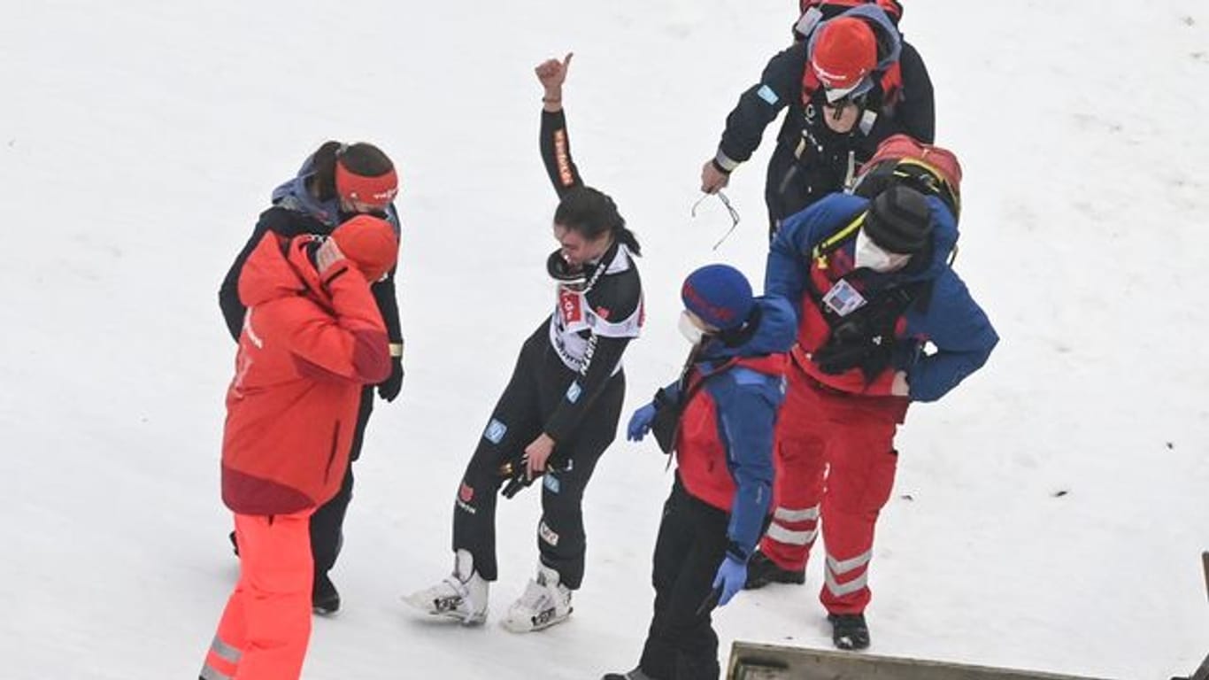 Selina Freitag (M) zeigt nach ihrem Sturz beim ersten Wertungsdurchgang von der Mühlenkopfschanze den Daumen nach oben.