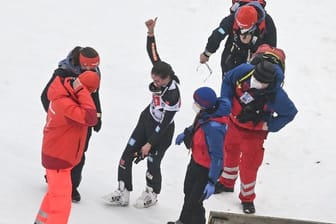 Selina Freitag (M) zeigt nach ihrem Sturz beim ersten Wertungsdurchgang von der Mühlenkopfschanze den Daumen nach oben.