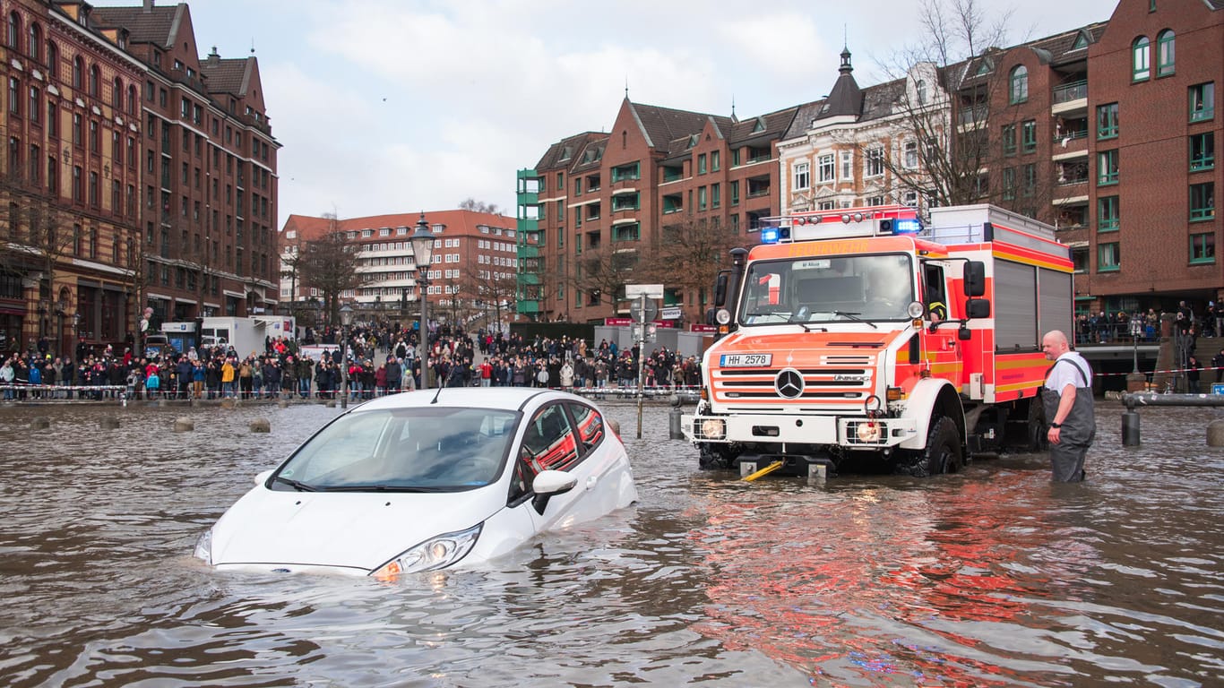 Ein Auto wird vom Fischmarkt gezogen: Das Hochwasser steht auch dort.