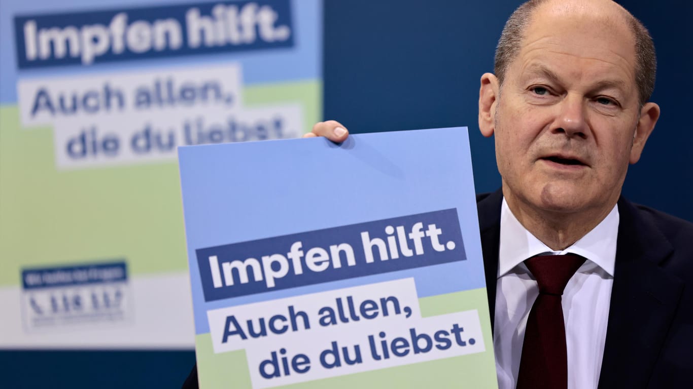 Bundeskanzler Olaf Scholz präsentiert ein Plakat für eine neue Impfkampagne: Bis Ende Januar sollten 80 Prozent der Menschen im Land ihre erste Spritze erhalten.