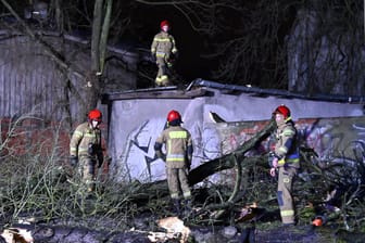 Sturmschäden in Polen: Feuerwehrleute räumen eine Straße, die durch einen umgestürzten Baum blockiert ist.