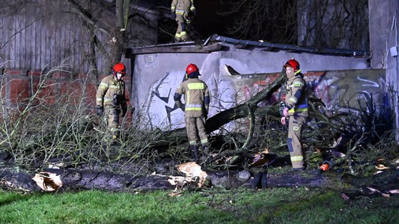 Feuerwehrleute räumen im polnischen Stettin eine Straße, die durch einen umgestürzten Baum blockiert ist.