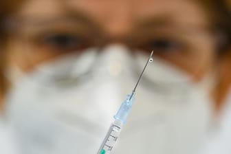 Eine Ärztin hält eine Spritze mit Corona-Impfstoff in einem Impfzentrum.